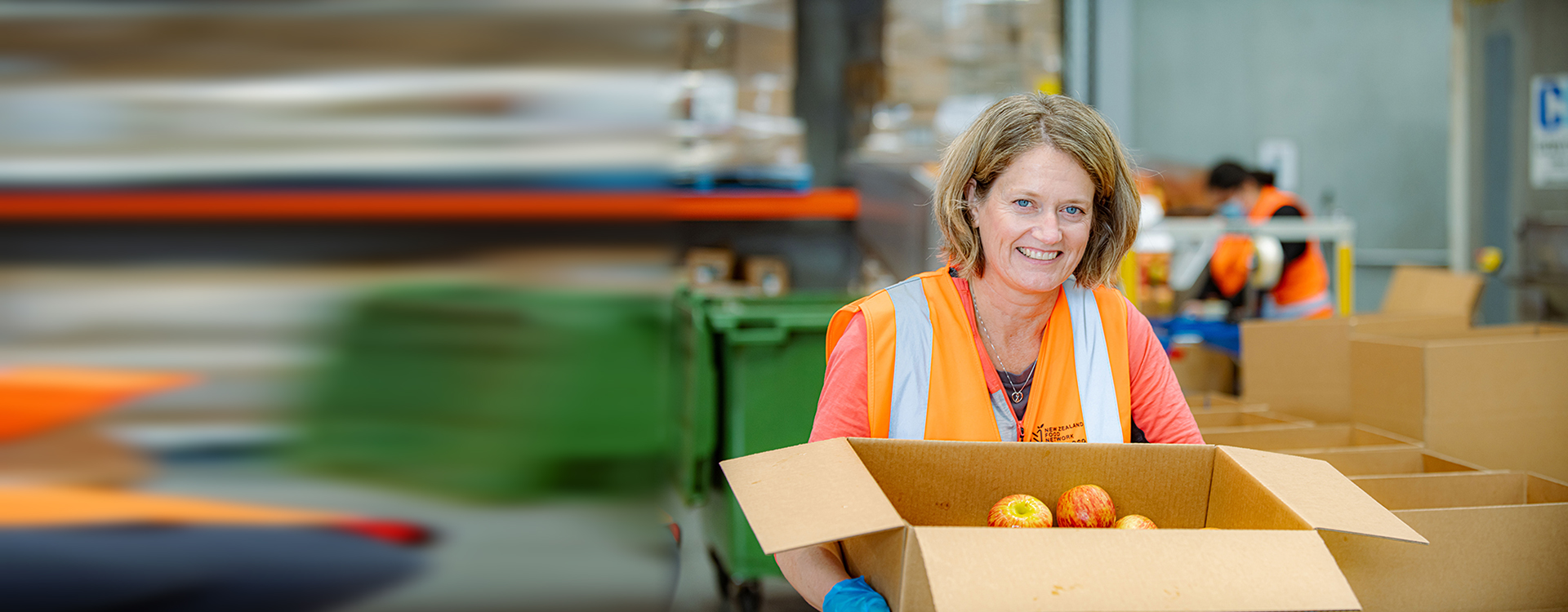 NZFN volunteer holding box of donated apples.