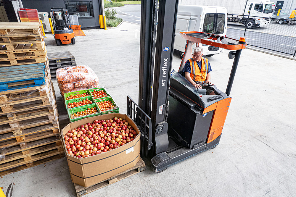 NZFN staff member picking up a pallet of donated apples on the hoist.