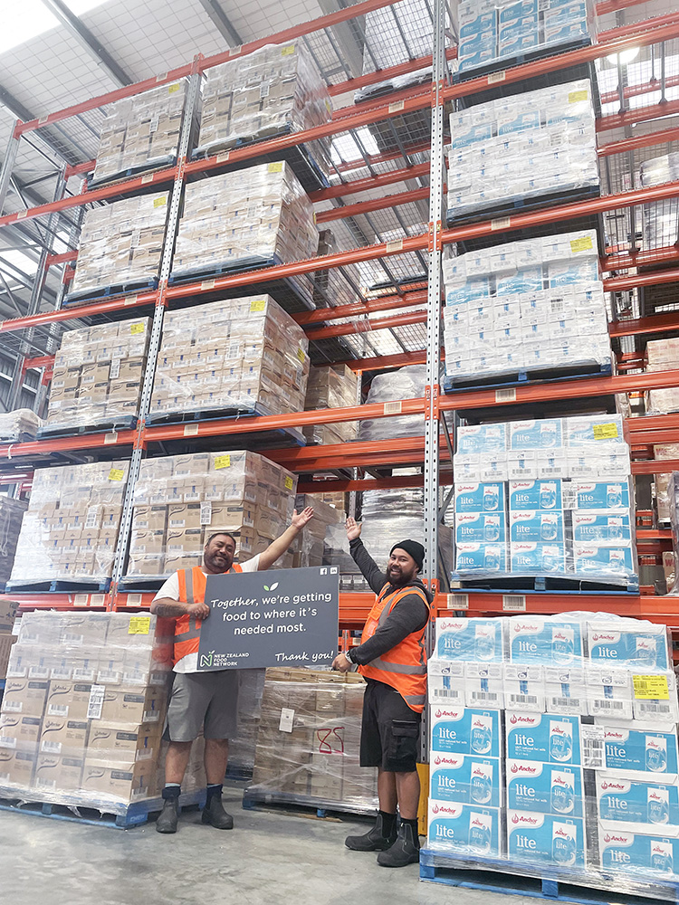 NZFN staff members holding a branded sign in front of a large donation from Fonterra.