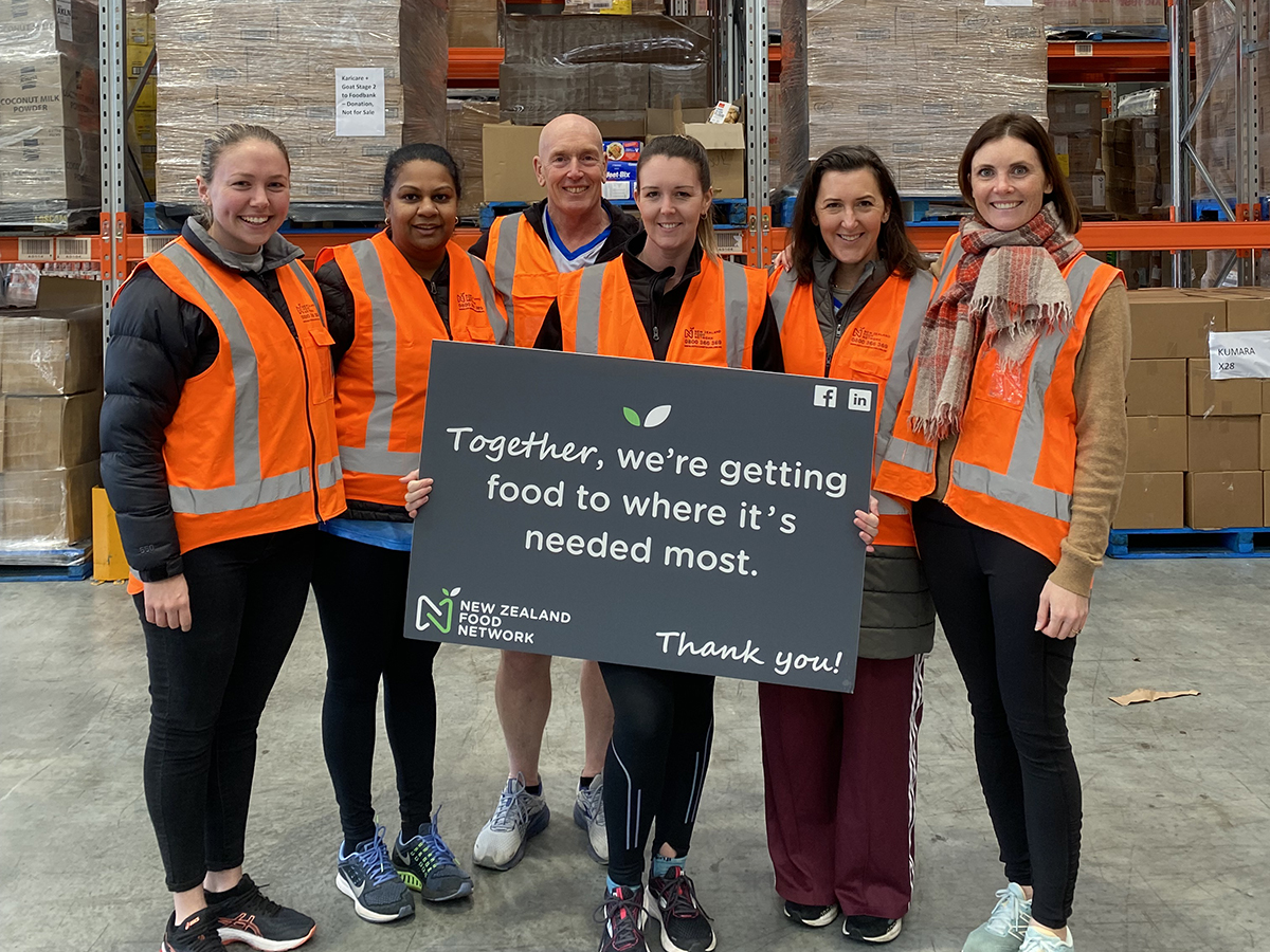 Enviro NZ staff volunteers grouped up holding a NZFN sign.