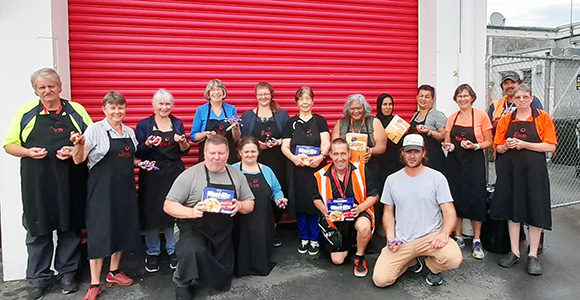 NZFN Food Hub, Just Zilch, team photo outside of their warehouse holding donated food.