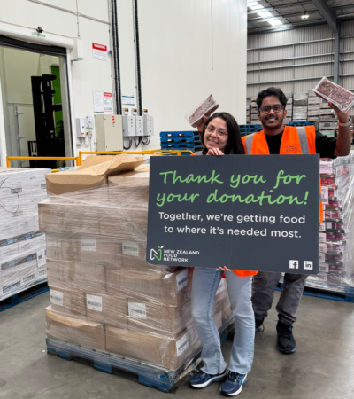 NZFN team members standing in front of a pallet of donated food, holding a sign saying Thank you for your donation