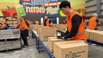 Volunteers packing food boxes in NZ Food Network food rescue partnership warehouse operations