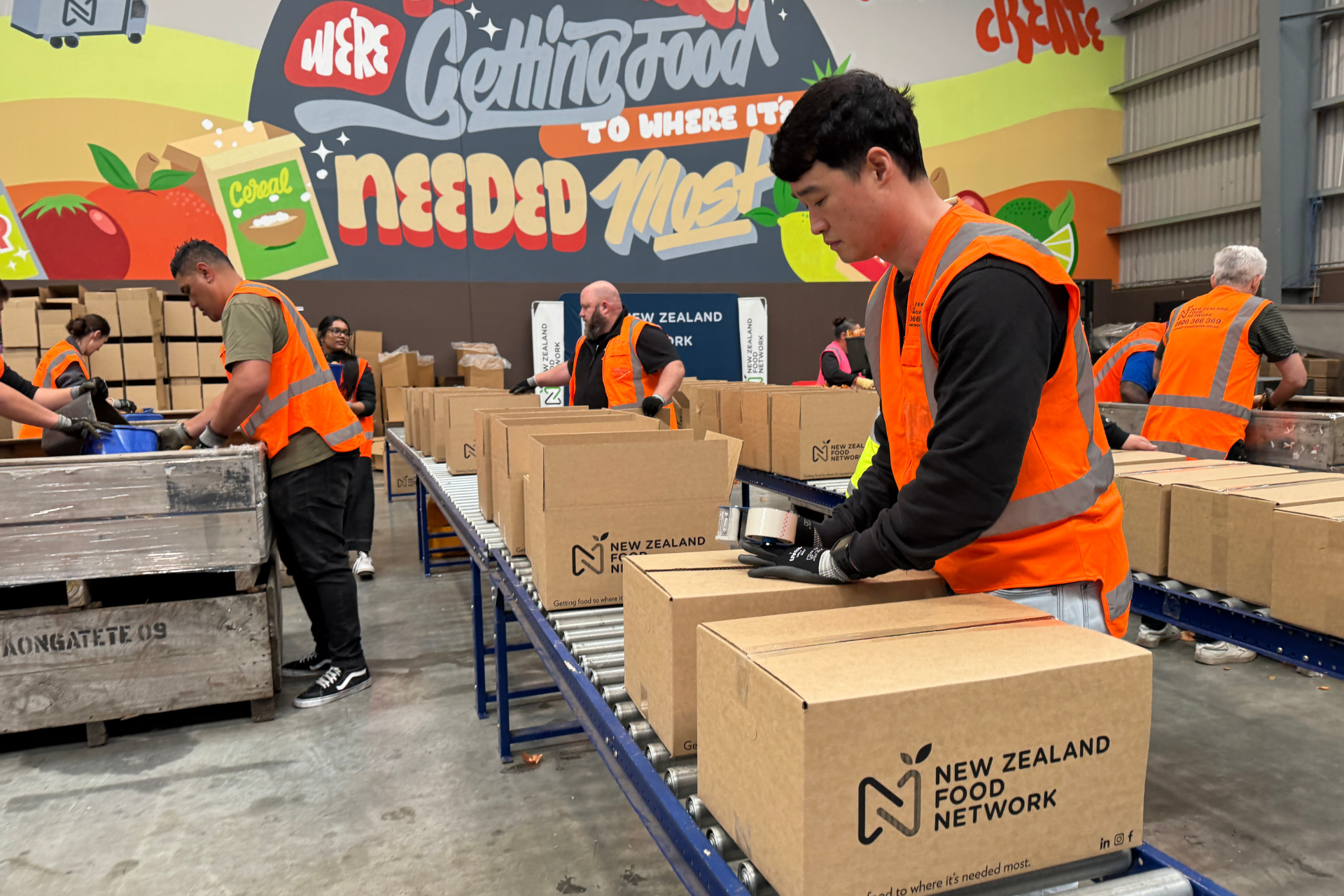 Volunteers packing food boxes in NZ Food Network food rescue partnership warehouse operations