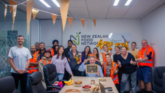 NZFN staff celebrating Best Places to Work Gold certification in office with certificate, decorations and team gathered.